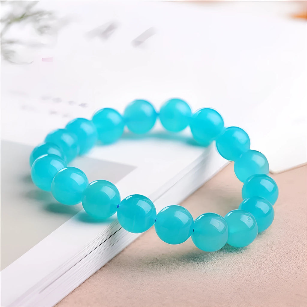 Selection of natural green Amazonite scattered beads in different sizes on a white background.