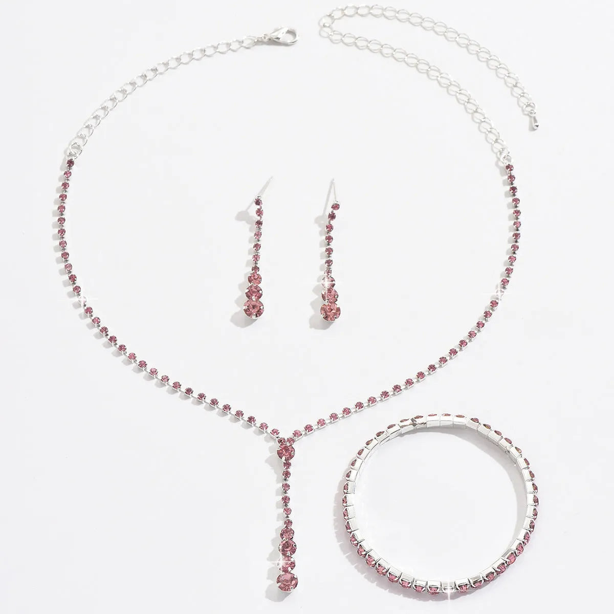 Women's three-piece bridal jewellery set showing earrings, necklace and bracelet with rhinestone heart-shaped pendant