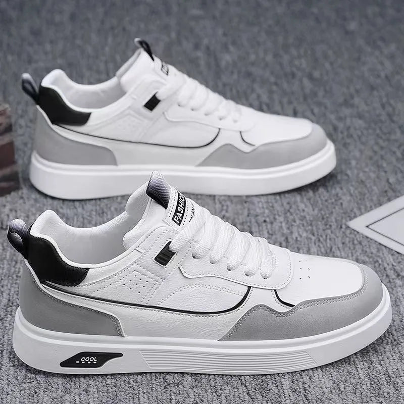 Men's low-top canvas shoes in grey with leather stitching detail on a white background