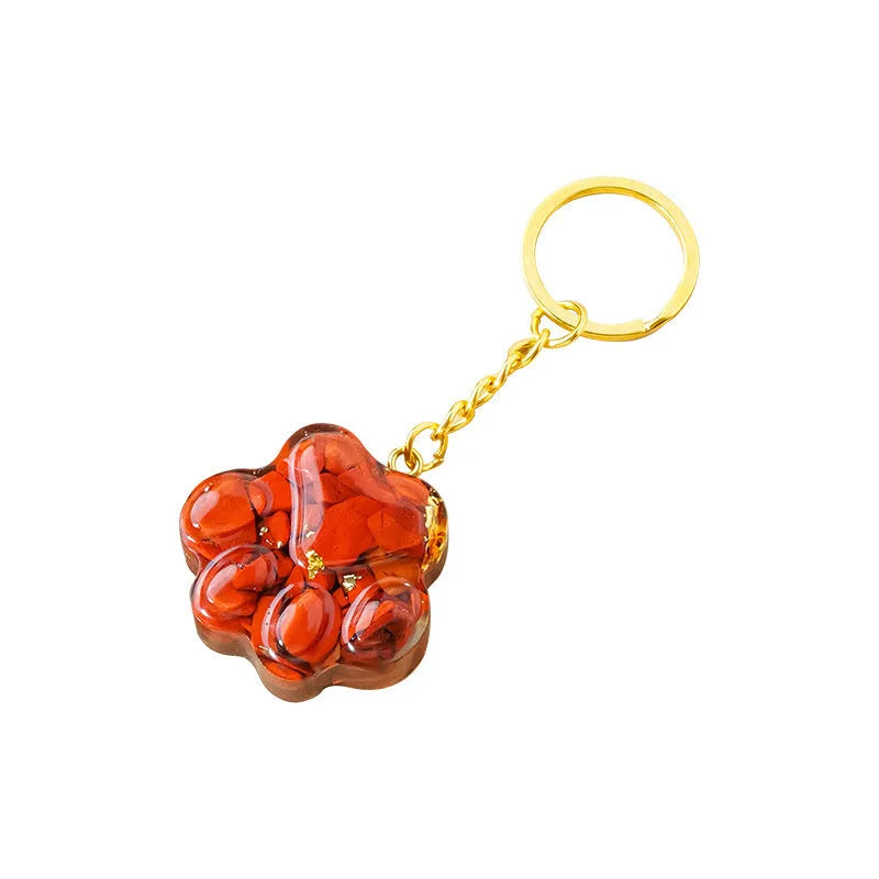 Natural crystal cat's paw shape pendant on a metal keyring, showing example of polished stone like turquoise or amethyst.