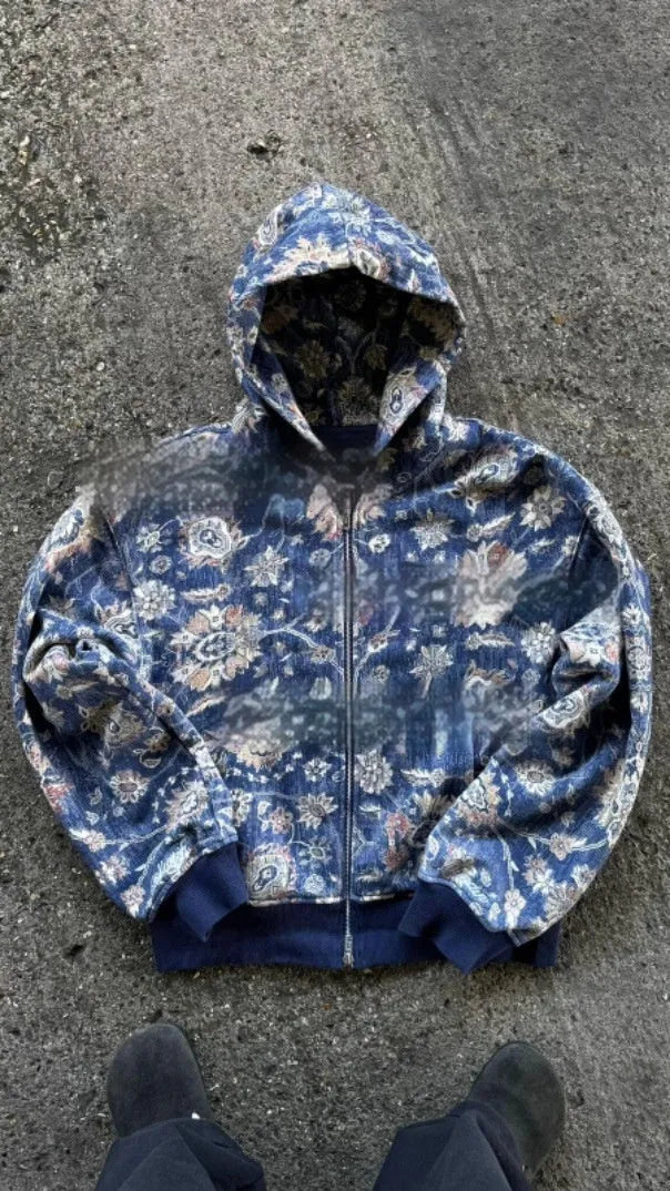 Man wearing a loose-fitting blue hooded zip-up coat with digital printing.