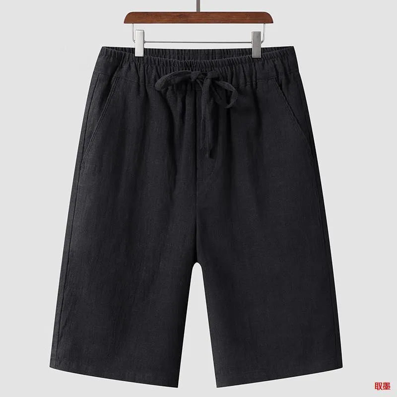 Pair of beige men's casual linen shorts with a loose fit and cropped length on a plain background.