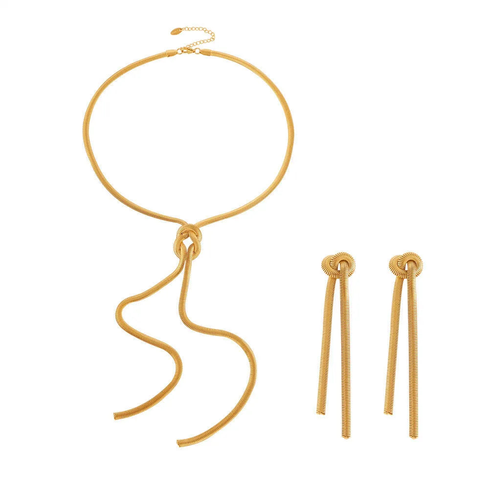 Gold titanium steel knotted tassel necklace and matching earrings set on white background