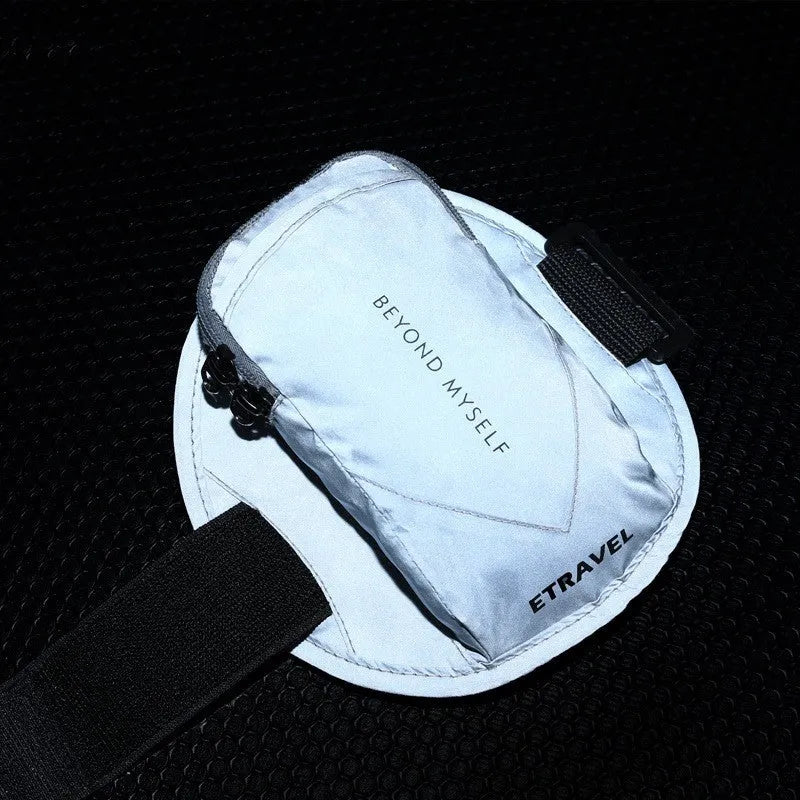 Black reflective running arm bag with adjustable strap, holding a mobile phone, shown on a runner's arm.