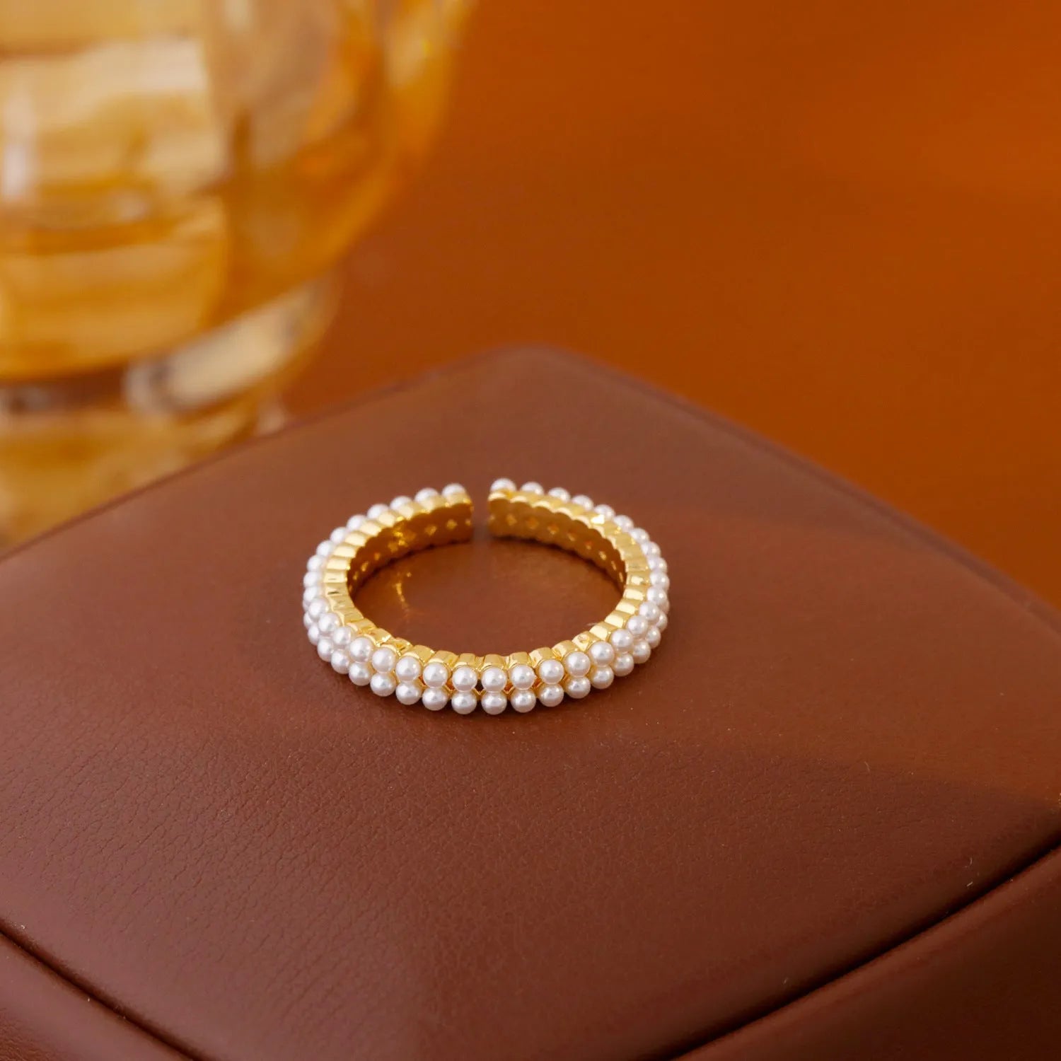 Gold electroplated open mouth pearl ring with geometry design on a copper base.