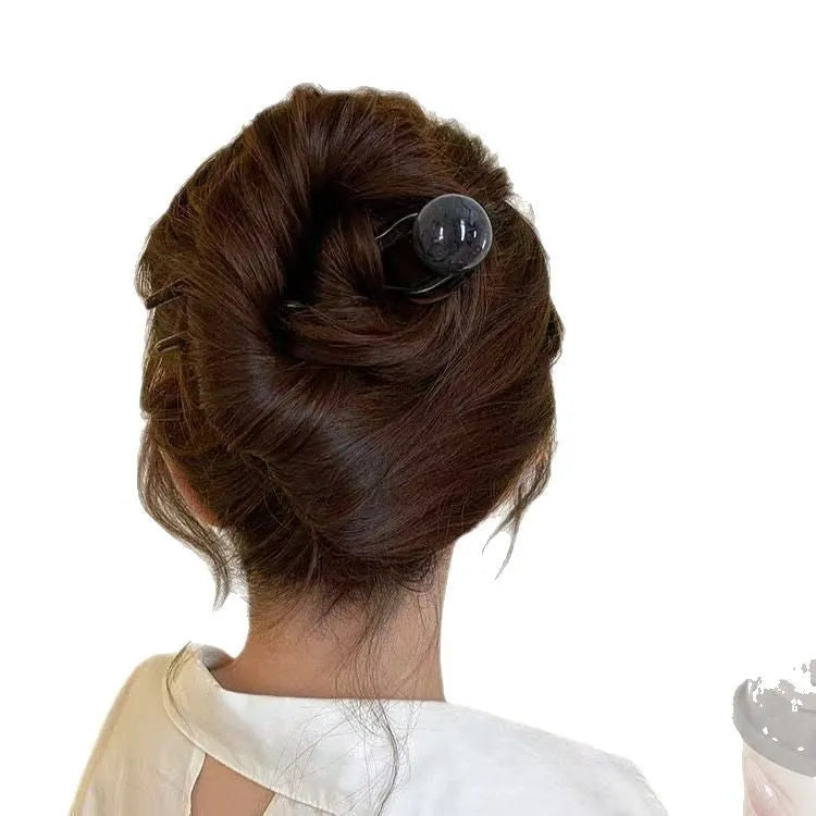 A set of U-shaped acrylic hair barrettes with a ball detail in beige, caramel, dark grey, and green colours