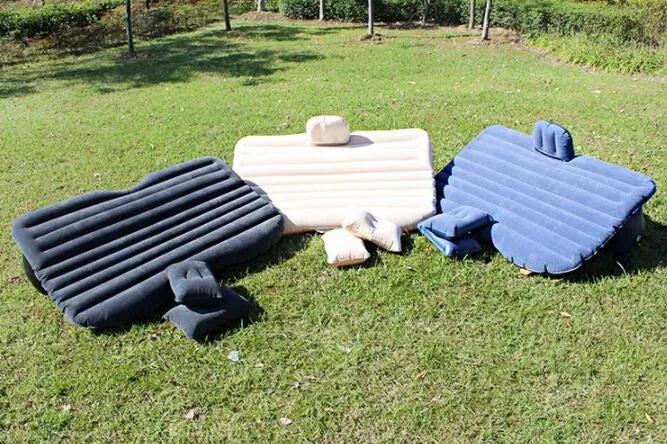 Inflatable car bed with flocking material shown in vehicle with two pillows and storage bag