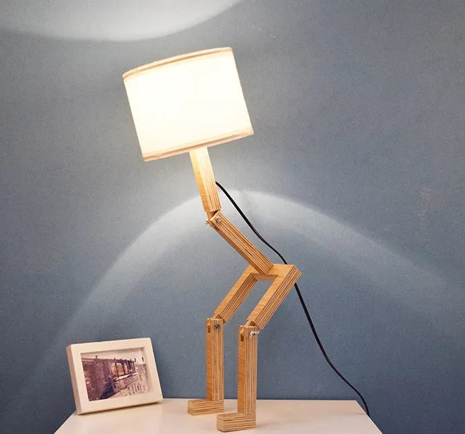 Creative wooden humanoid table lamp with white fabric shade on desk, 22x44x16 cm, button switch