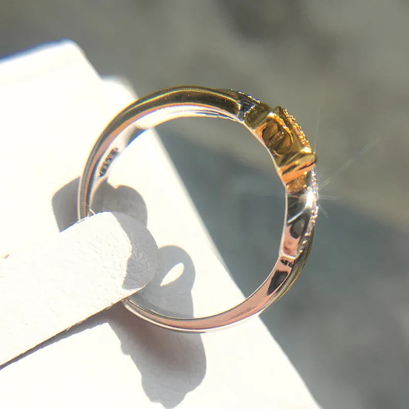 18k yellow gold plated ribbon engagement ring with pink diamond inlay on white background