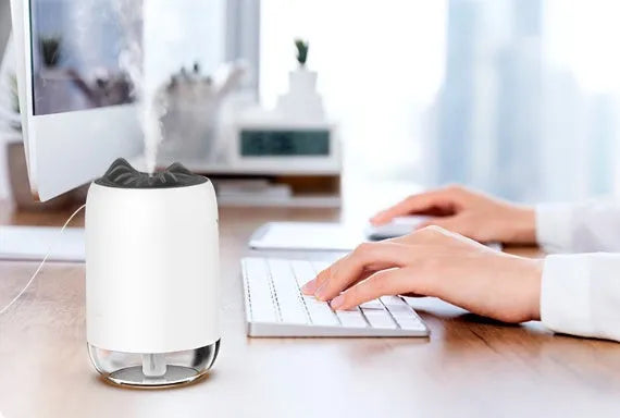 Compact cylindrical mini USB humidifier in turquoise green with a single mist outlet and night light.