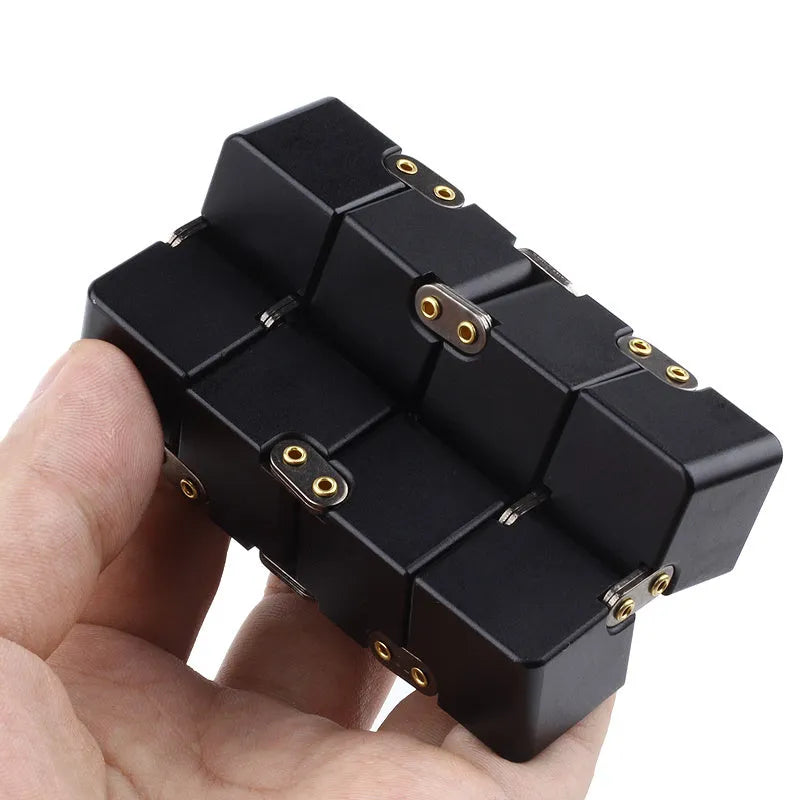 Zinc alloy infinity cube fidget toy showing black and silver rotating cube puzzle on a desk.