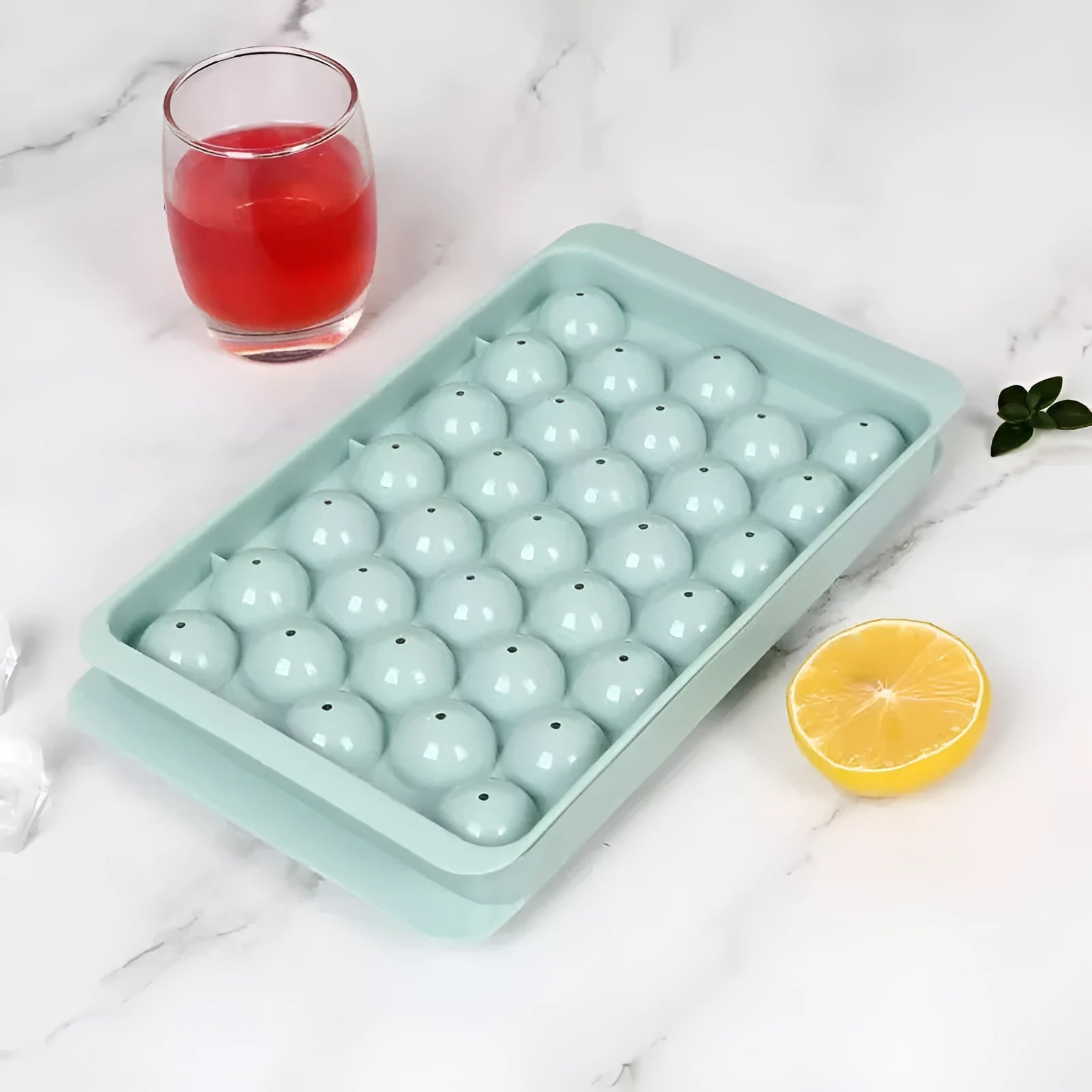 Blue silicone ice cube tray with lid showing 33 round moulds for homemade ice.