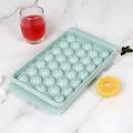 Blue silicone ice cube tray with lid showing 33 round cavities.