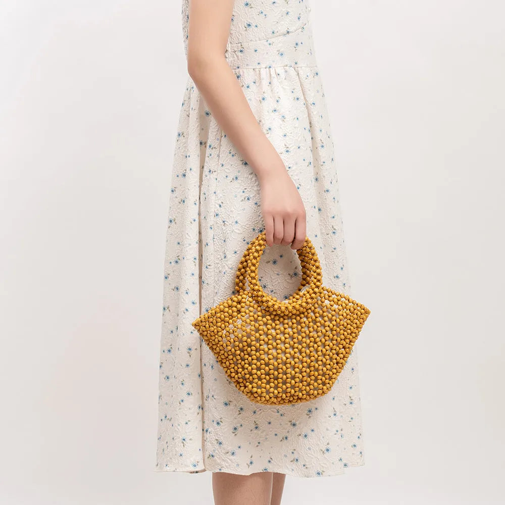 Hand-woven dumpling-shaped maple beach handbag with wooden bead decoration in milky white colour