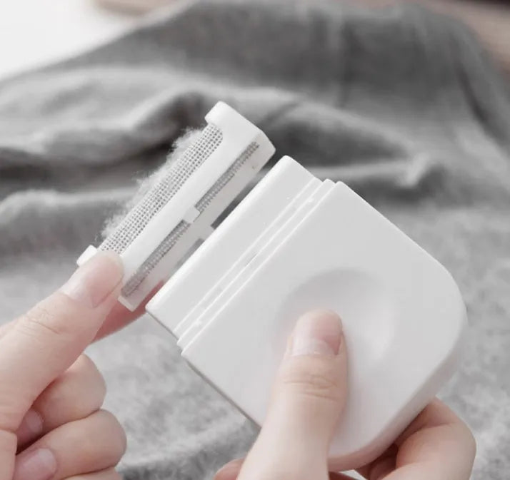 Portable manual clothes cleaning brush with removable catching net on a sweater