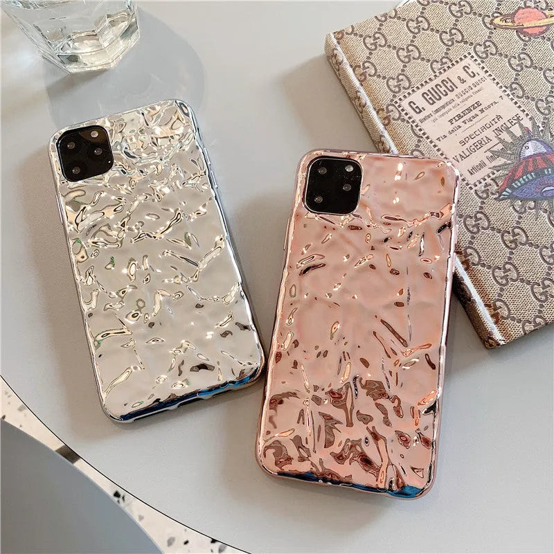 Electroplated rose gold TPU folded back case for iPhone on a table.