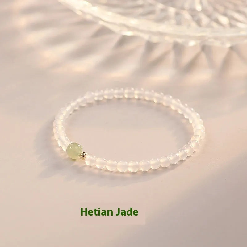 Close-up of a women's bracelet with white agate and Hetian jade beads on a 15 cm strand.