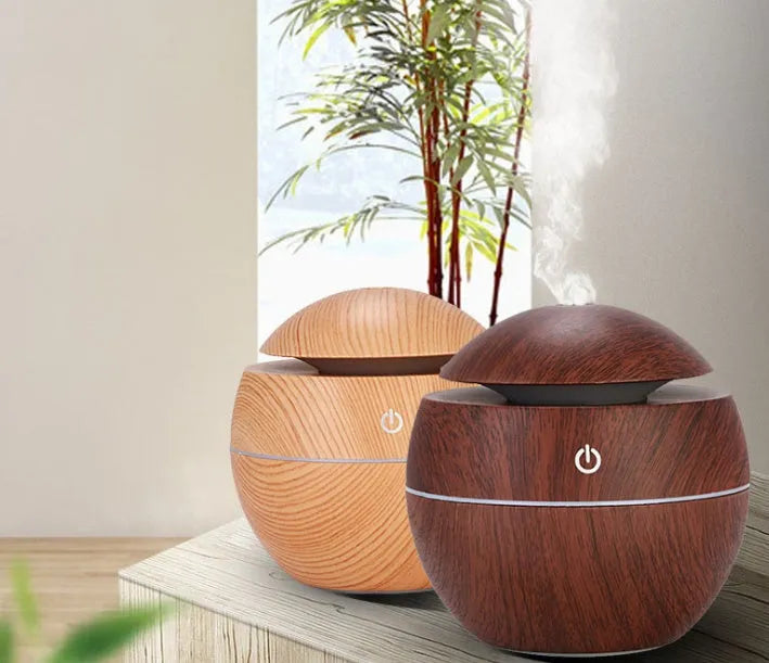 USB aroma diffuser humidifier in light wood grain, 100x100x95mm, 130ml tank, coloured lights on desk