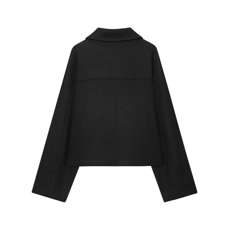 Short double breasted woolen coat in black with front pockets on a woman for commute wear