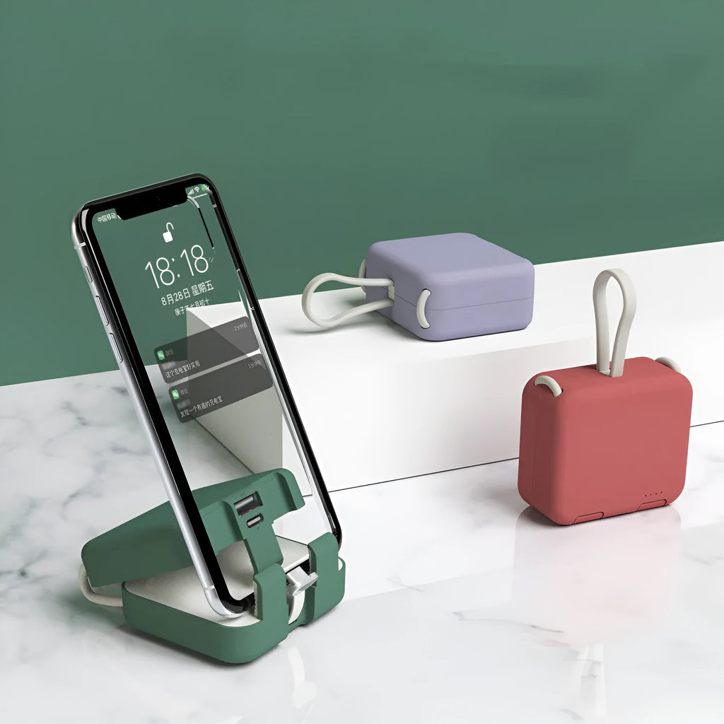 Handbag clip-on portable power bank in blue, shown charging a phone and functioning as a stand.