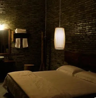 Small bamboo plaited wall light with natural finish, shown mounted on a wall.