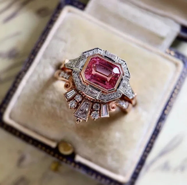 Rose gold alloy women's ring with a geometric design and ruby-coloured stone in a retro style.