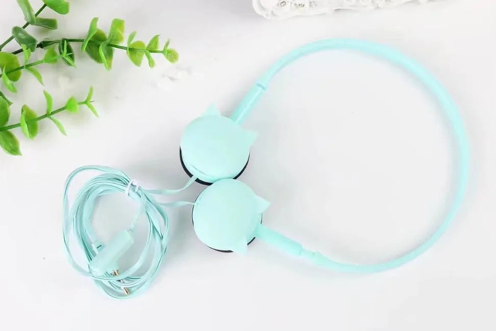 Kitten ear headphones in black with head-mounted design and 3.5mm plug on a desk next to a laptop.