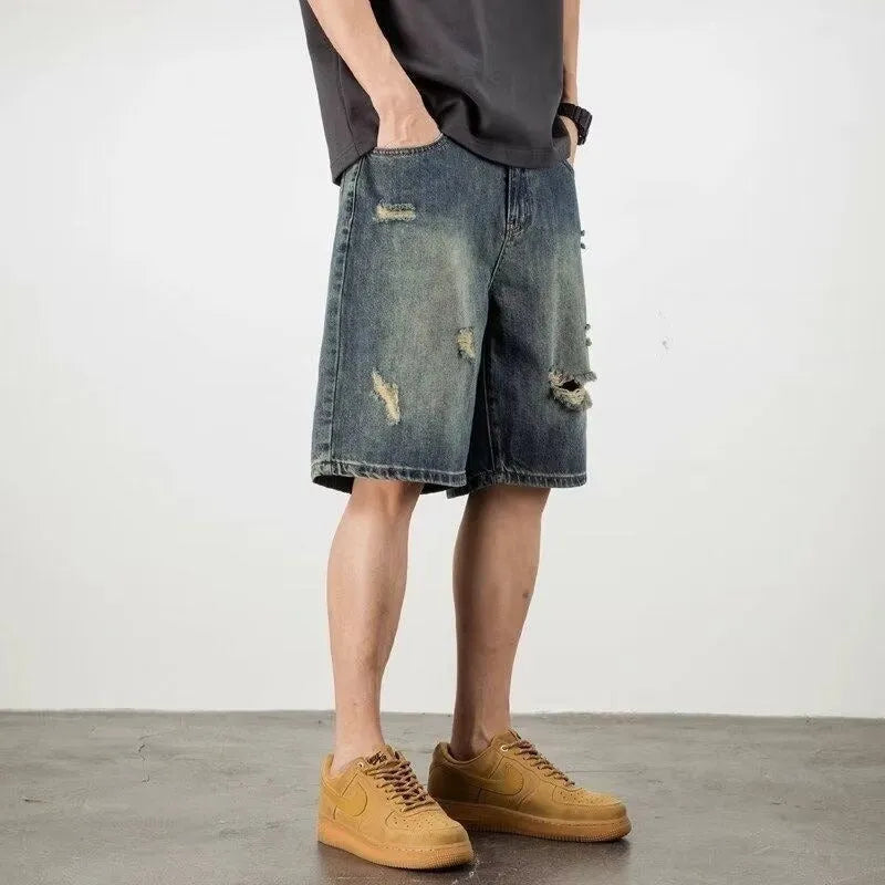 Man wearing blue retro loose hole distressed denim shorts with a straight leg cut