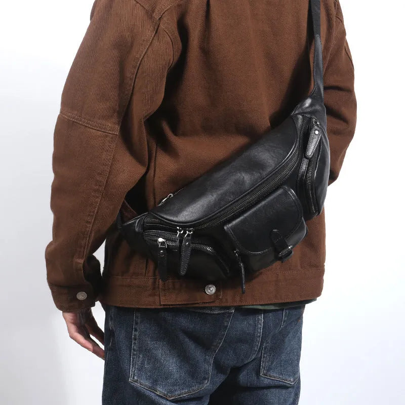 Black slanted chest bag in first layer cowhide with lock detail and polyester lining for daily commute