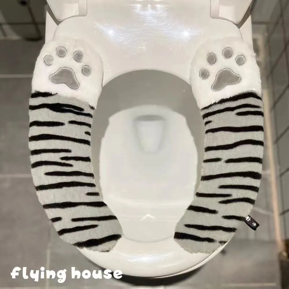 Plush toilet seat cushion with adhesive Velcro fastener in black and white stripes for bathroom use