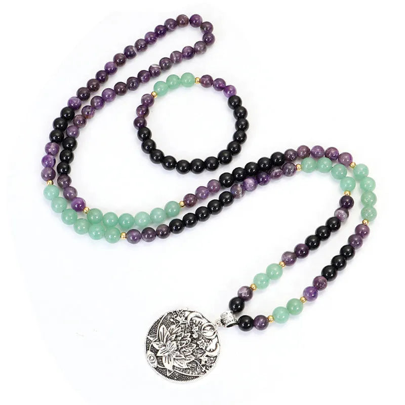 Yoga lotus pendant necklace and bracelet set with stone beads on a white background