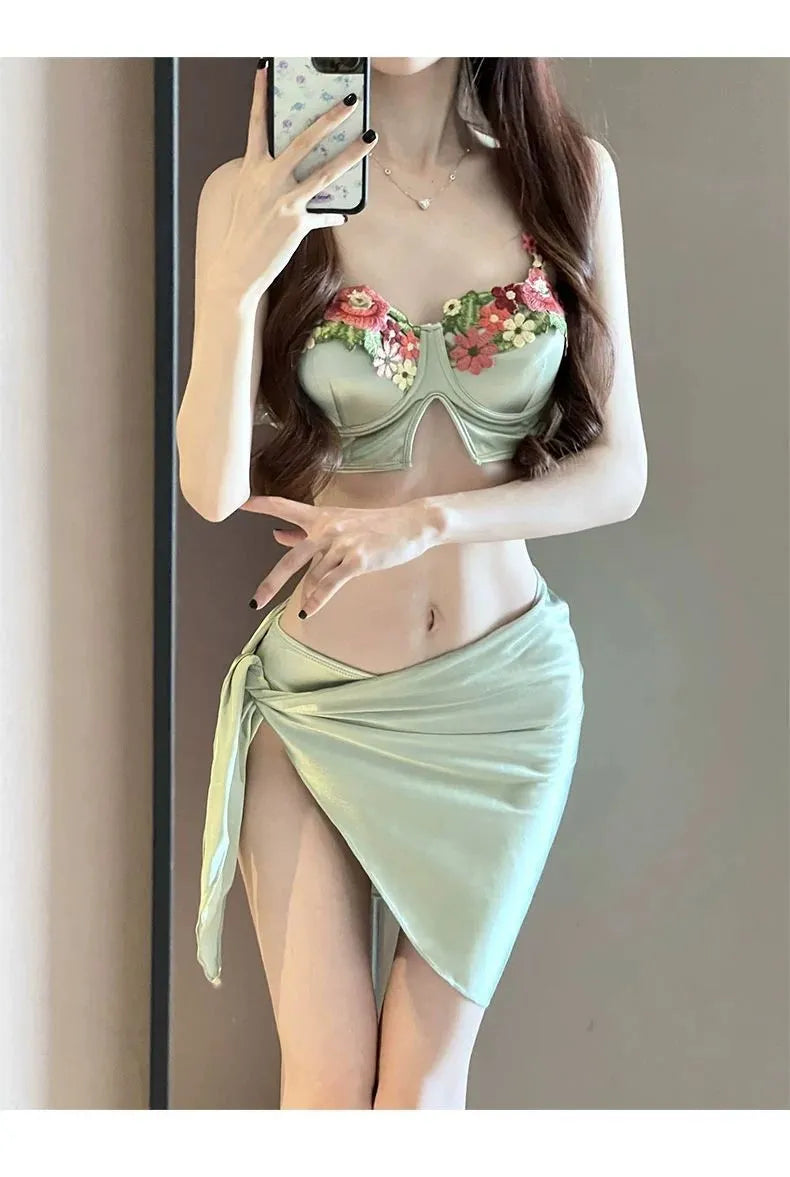 Green women's bikini three-piece set with triangle top, briefs, and skirt cover-up
