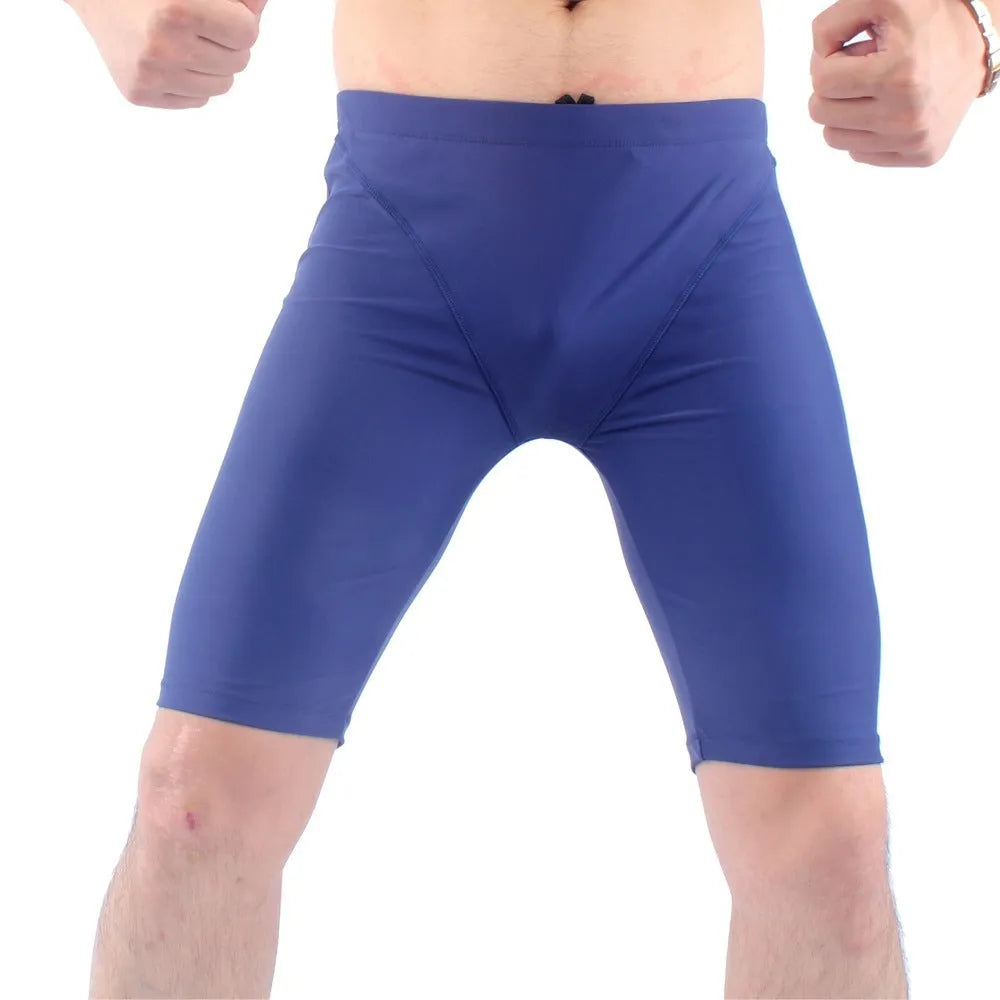 Men's green loose-fit five-point swimming trunks made from quick-drying nylon fabric.