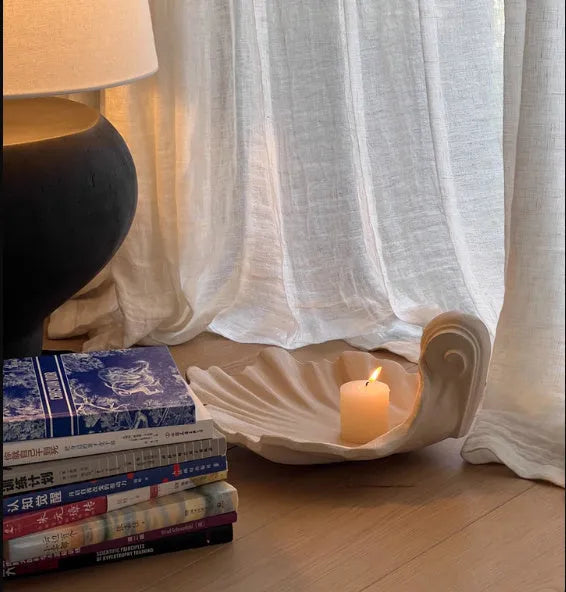White resin fruit plate ornament shaped like a shell on a table