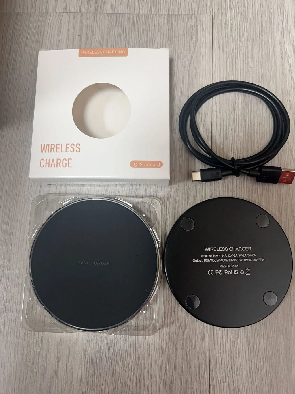 Black 15W fast wireless charger pad with type C cable on a desk