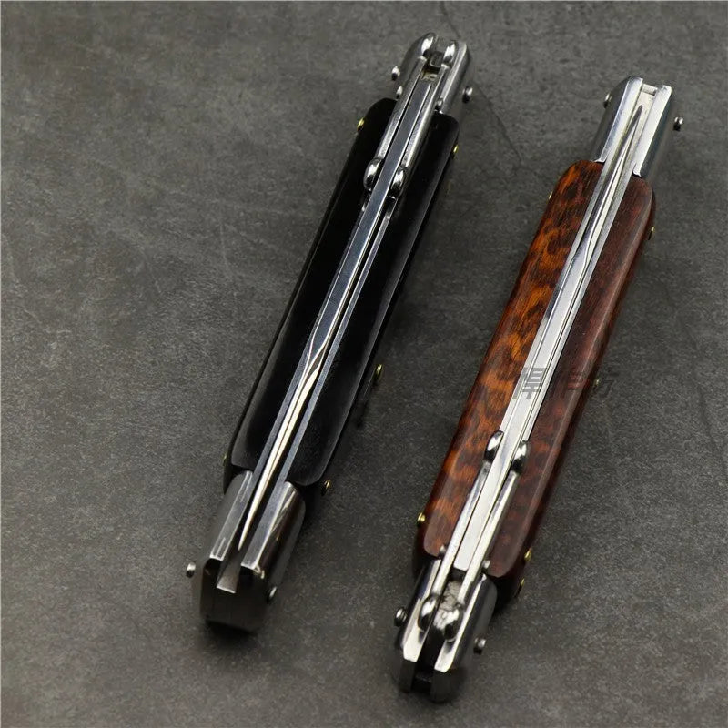 Damascus folding knife with 9.8cm blade and snake wood handle on outdoor wood surface