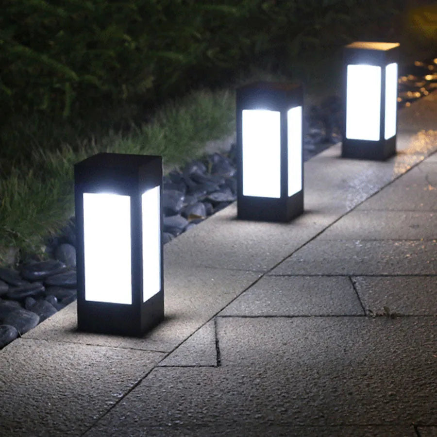 Set of solar-powered LED garden lights in different styles mounted on a garden wall and path