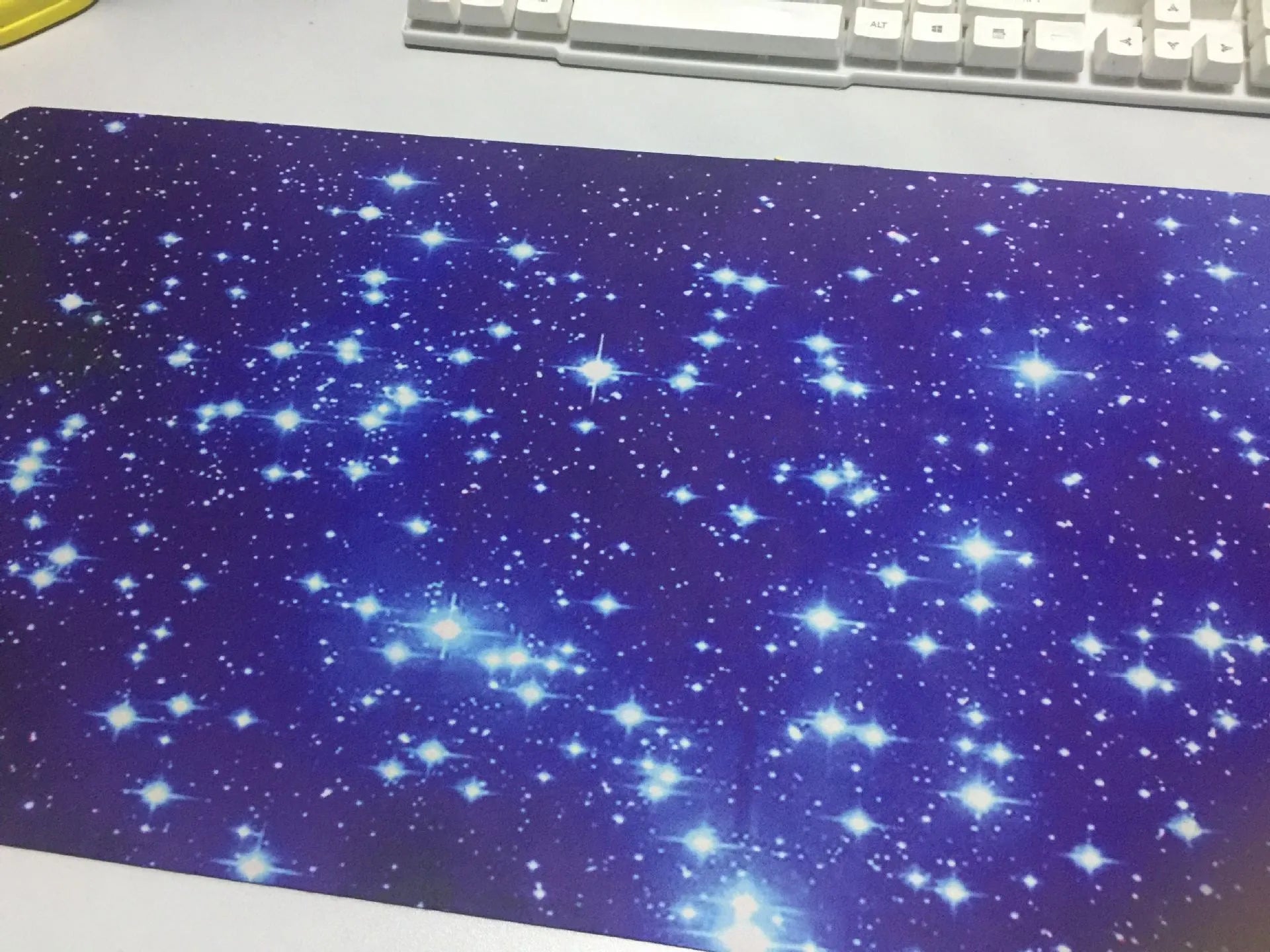 Blue star mouse pad with high-density fabric surface and anti-skid rubber base on a desk