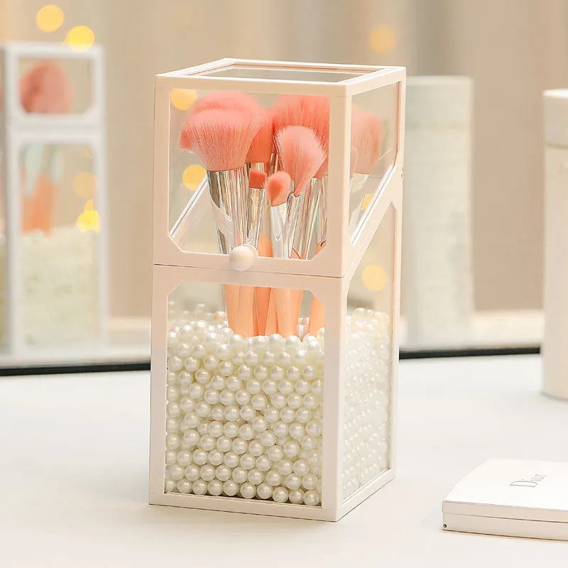 Transparent glass makeup brush bucket with black lid on white surface showing brushes inside