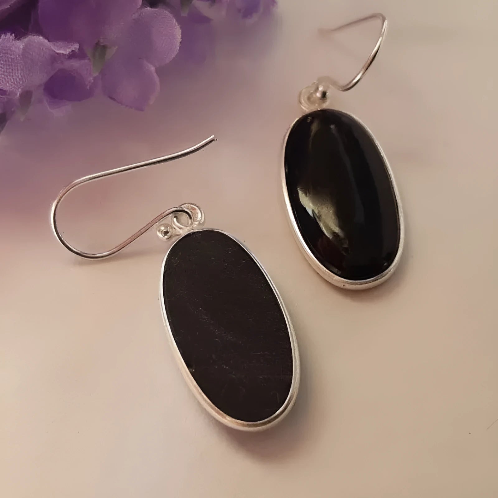 A pair of women's geometric earrings with a black agate oval pendant on alloy settings.