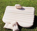 Inflatable car bed with flocking material shown in vehicle with two pillows and storage bag