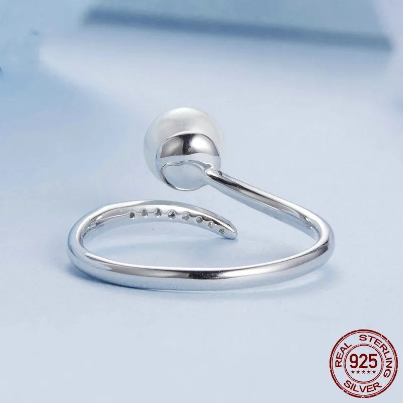 Close-up of an adjustable S925 sterling silver ring featuring a natural shell pearl on an open loop band.