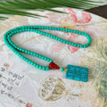 Turquoise ball bead necklace with a hand-woven mesh flower lucky pendant in stone.