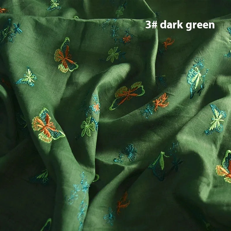 Close-up of textured 100% ramie fabric in beige, grass green, and dark green colours, showing its width.