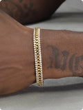 Gold-coloured hip hop style tennis bracelet for men and women on a wrist.