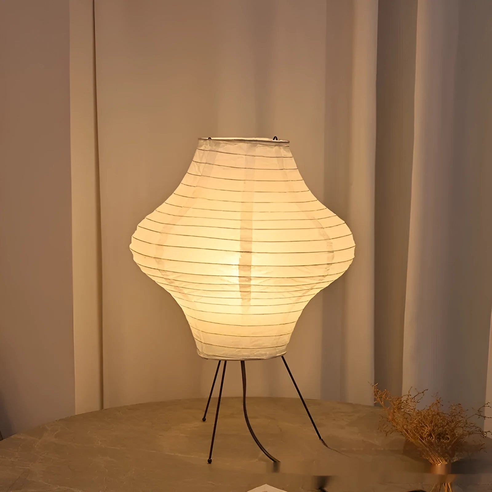 Japanese style table lamp with a white paper shade and a wooden base on a table.