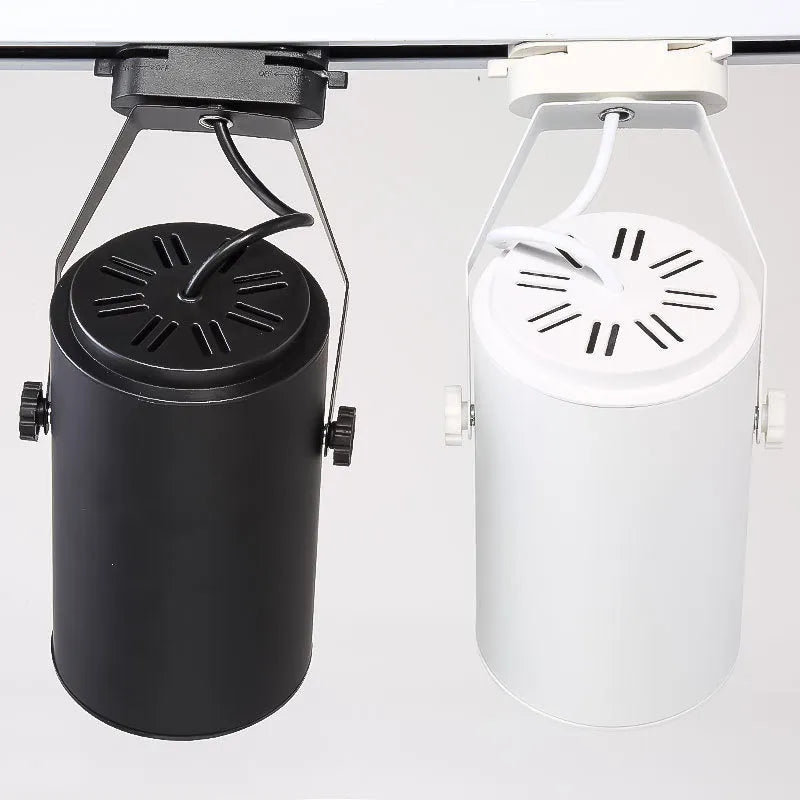 Black and white aluminium LED track spotlight on a lighting track, aimed at a display.