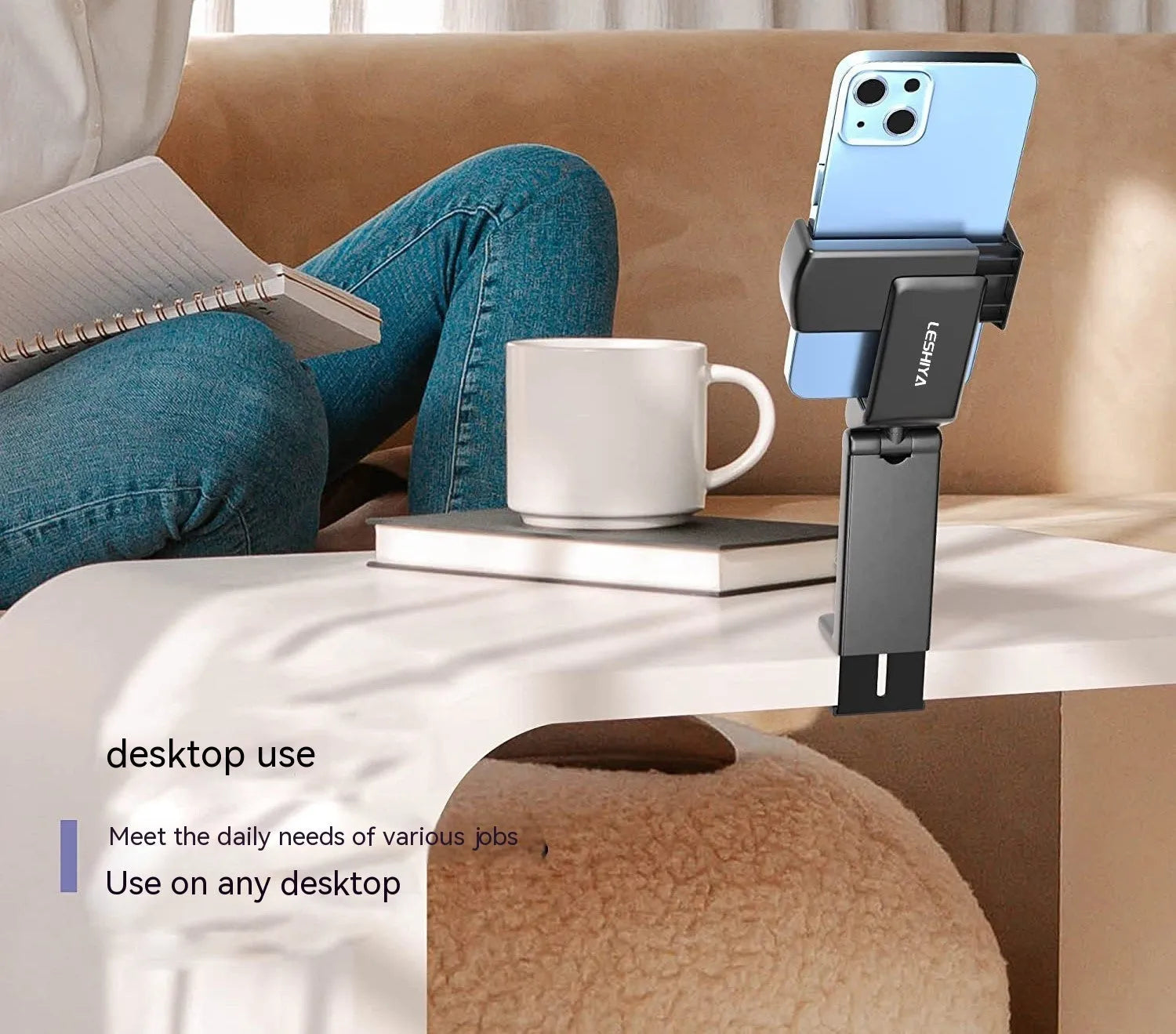 Black foldable rotating universal phone holder made of ABS plastic on a table.