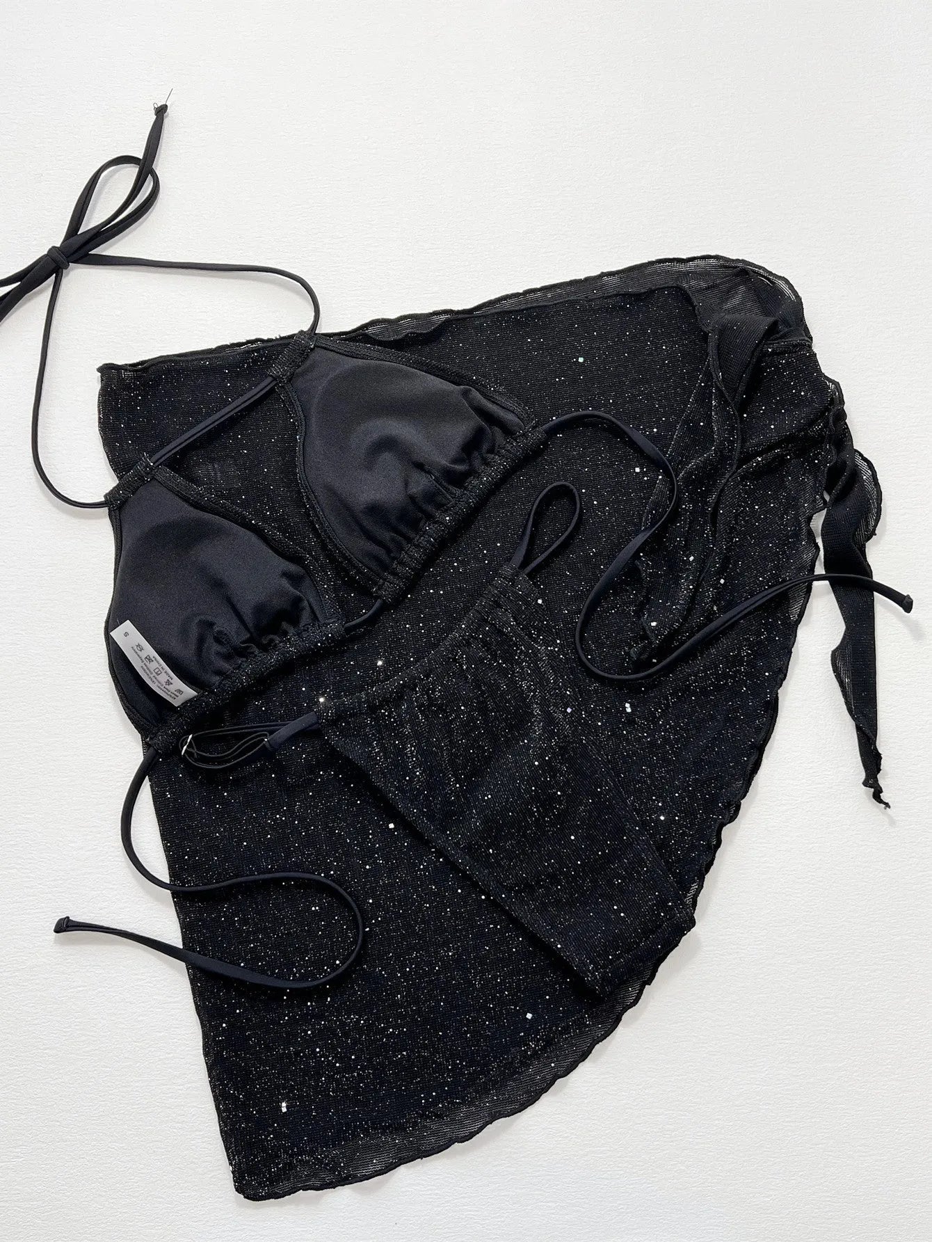 Black three-piece bikini swimsuit set with matching top and shorts on white background