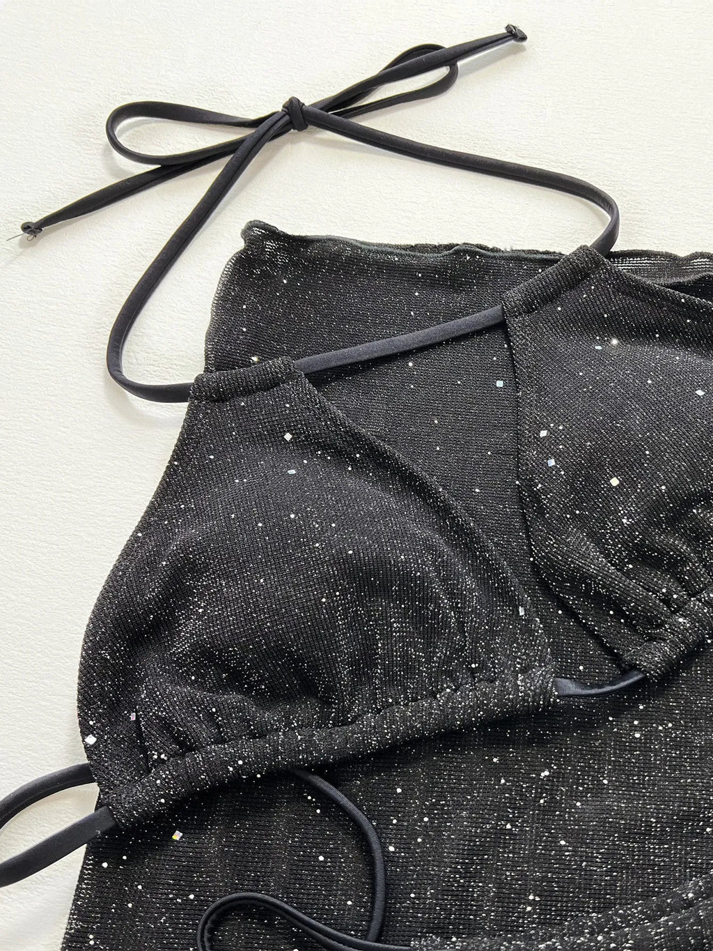 Black three-piece bikini swimsuit set with matching top and shorts on white background